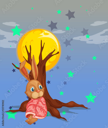 A bunny resting beside the big tree