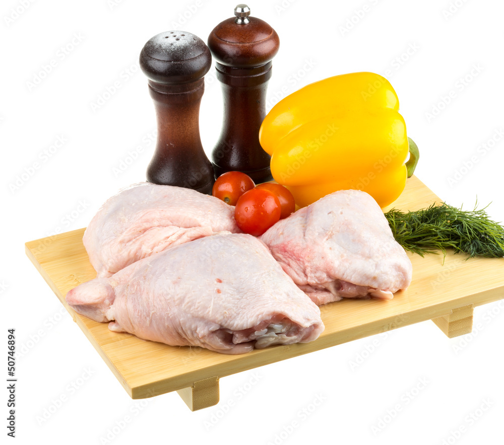 Fresh raw chicken wings on chopping board with roma tomatoes Fresh raw chicken wings on chopping board with roma tomatoes