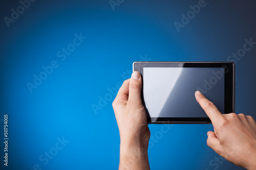 Hands holding Tablet PC on blue