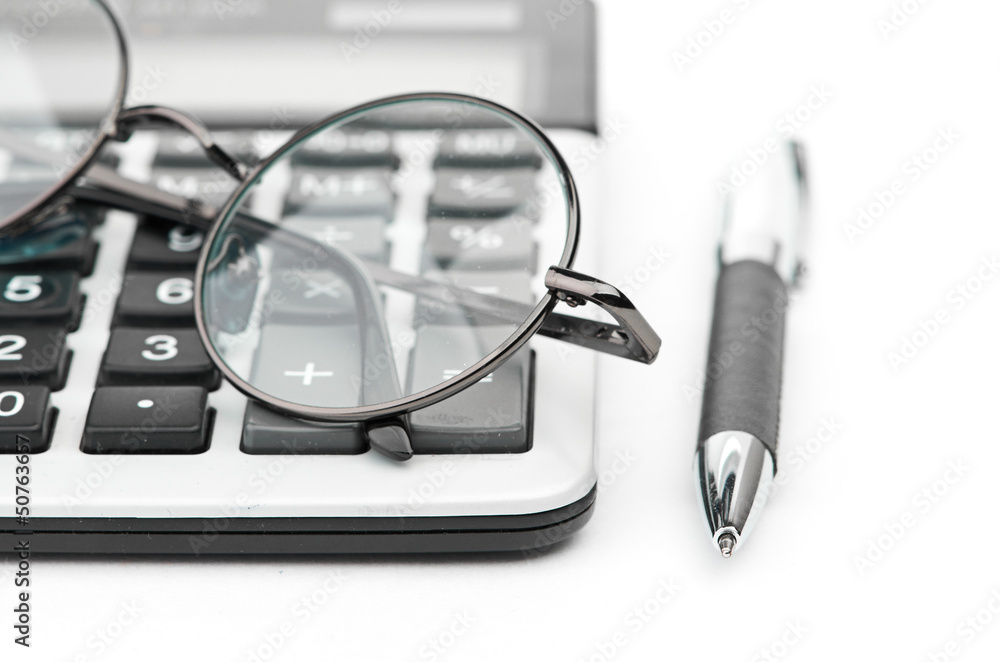 glasses and pen on calculator glasses and pen on calculator