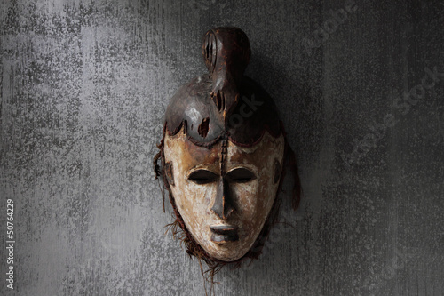 masque africain sur mur patiné