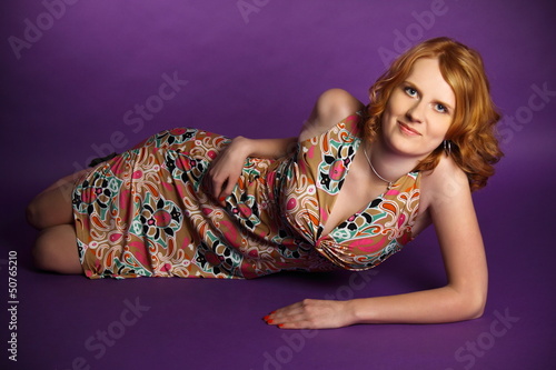 Redhead in a dress on a violet background © speldin