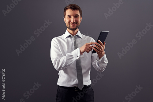 smiley businessman pointing at tablet pc