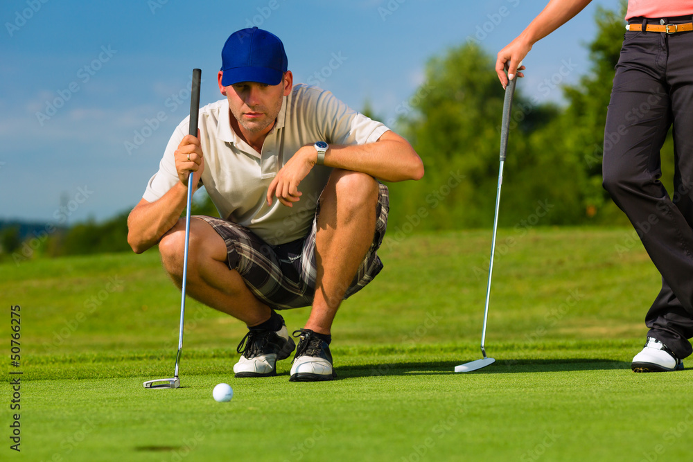 Obraz premium Young sportive couple playing golf on a course