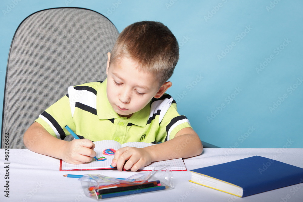 Young cute boy draws with color pencils Young cute boy draws with color pencils