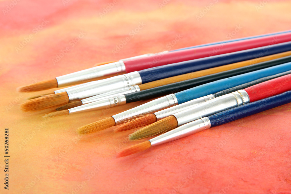 brushes on bright abstract gouache painted background brushes on bright abstract gouache painted background