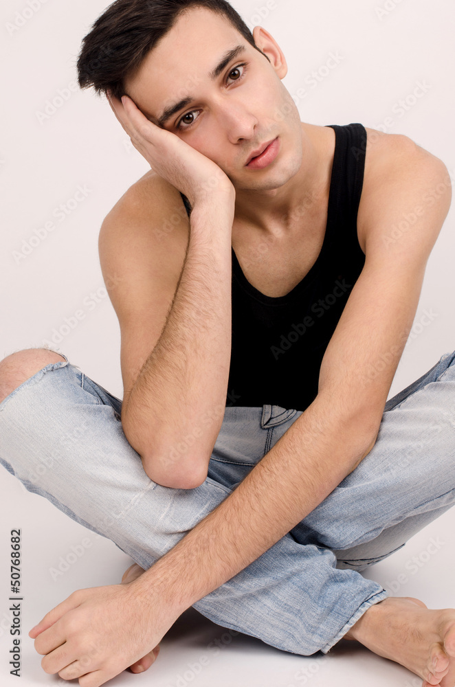 Attractive man in ripped jeans and black top chilling. Attractive man in ripped jeans and black top chilling.