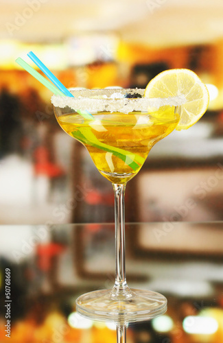 Yellow cocktail in glass on room background