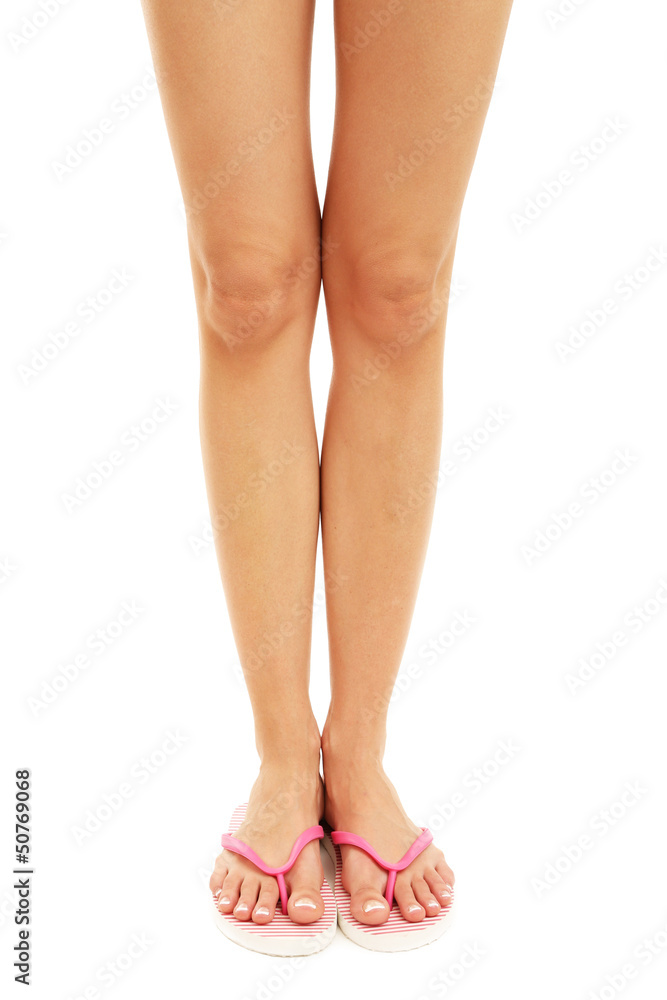 Beautiful woman legs in summer slippers, isolated on white Beautiful woman legs in summer slippers, isolated on white