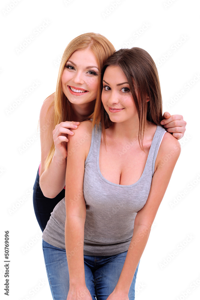 Two girl friends smiling isolated on white Two girl friends smiling isolated on white
