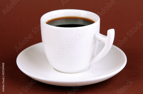 Cup of strong coffee on brown background
