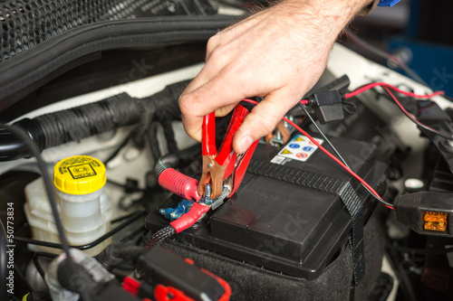 Car mechanic changing the battery