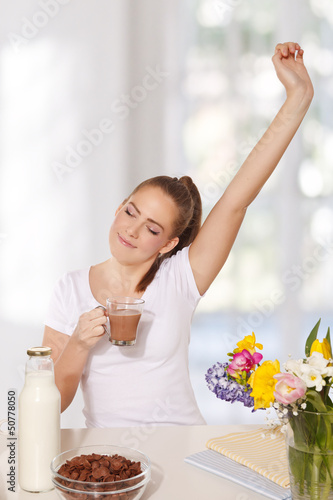 Quadro em tela Beautiful young woman streching herself while holding a glass of