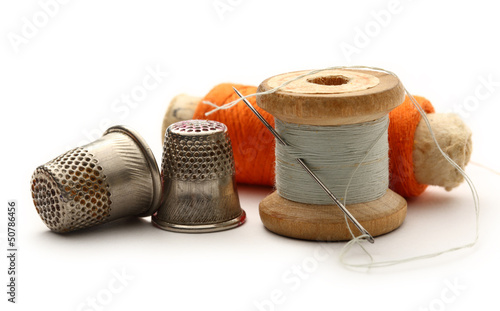 Sewing thimbles, bobbins and needle photo