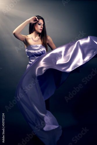 Beautiful fashion woman in violet long dress