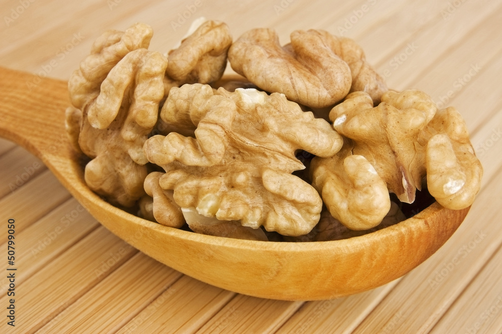Shelled walnuts in wooden spoon close up Shelled walnuts in wooden spoon close up