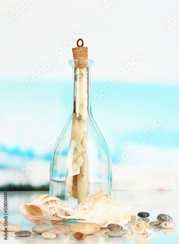 Original glass bottle with letter on sea background