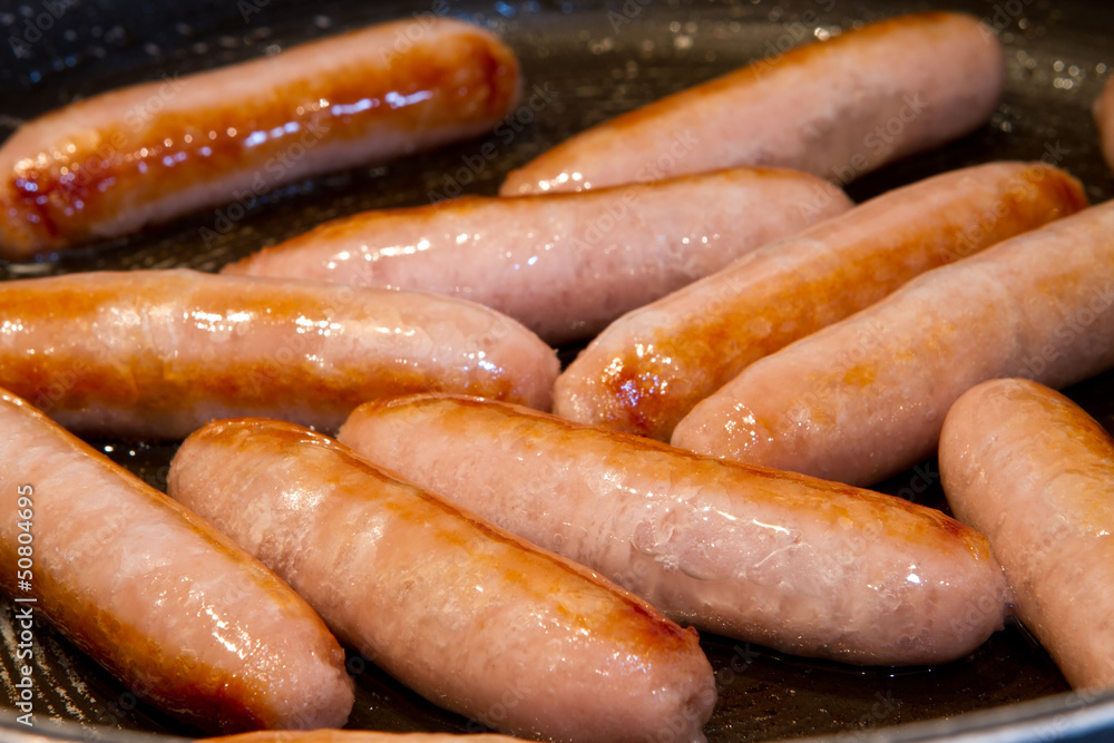 sausages frying in oil in the pan sausages frying in oil in the pan