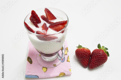 glass of yogurt with strawberries  isolated on white photo
