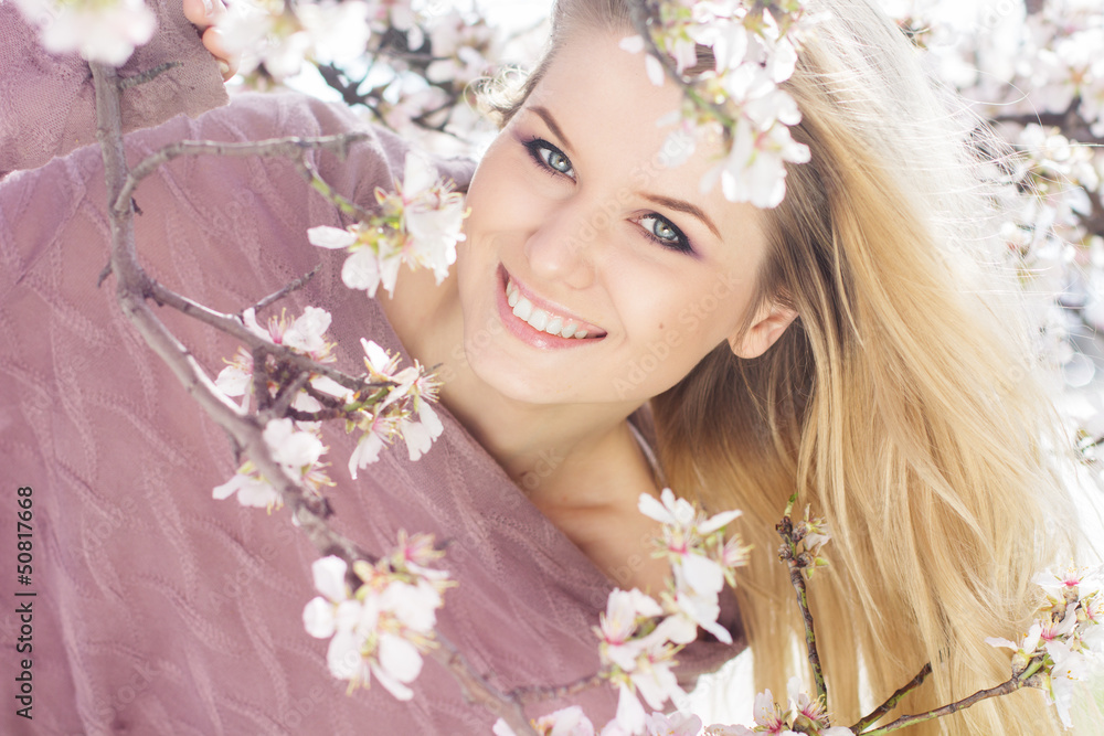 Fototapeta premium beautiful blonde girl in spring cherry garden