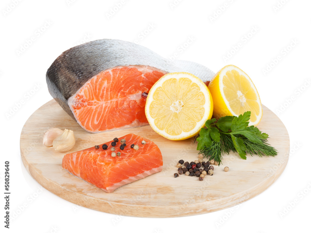 Salmon with herbs and lemon slices on cutting board