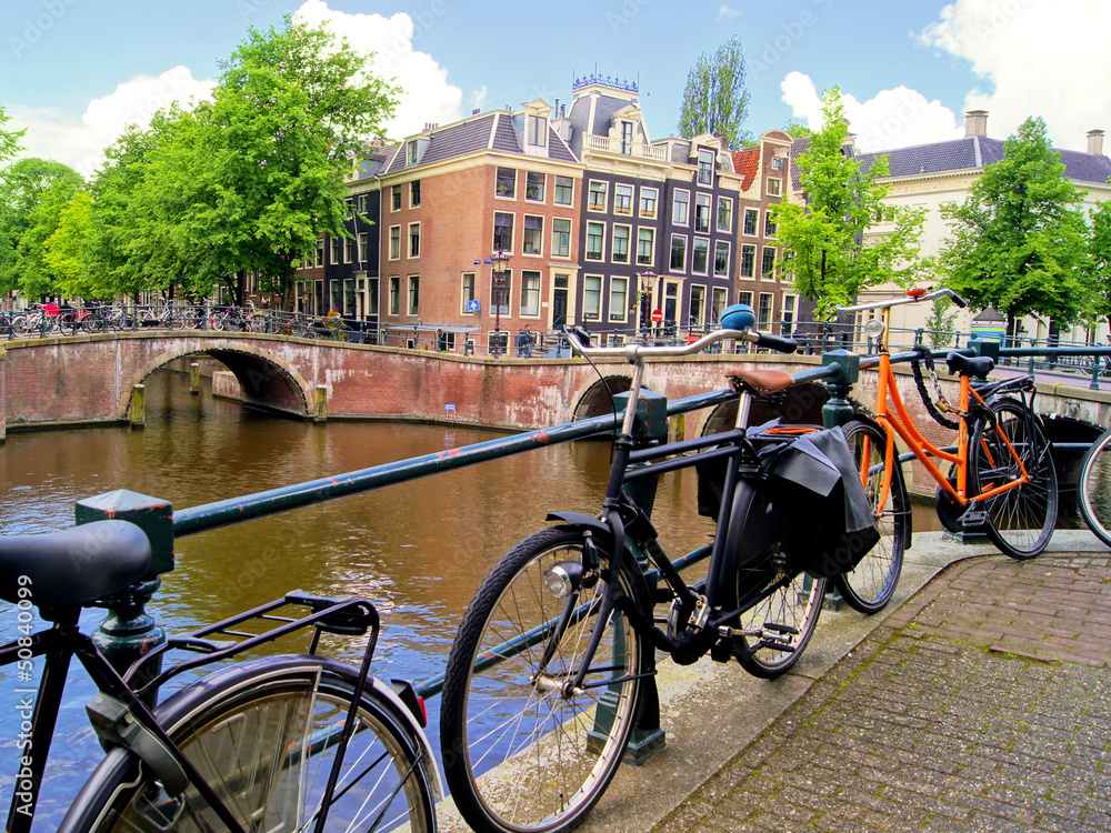 Fototapeta premium Amsterdam canal scence with bicycles and bridges