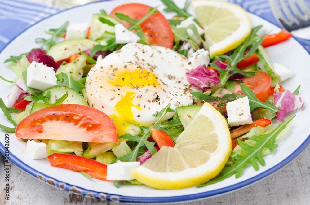 Vegetable salad with poached egg on a plate, closeup Vegetable salad with poached egg on a plate, closeup