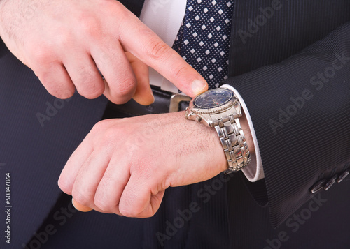 Businessman pointing at his wristwatch.