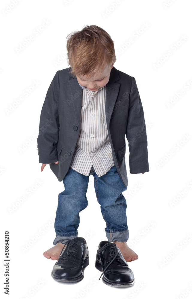Little boy on the big shoes. Isolated on white