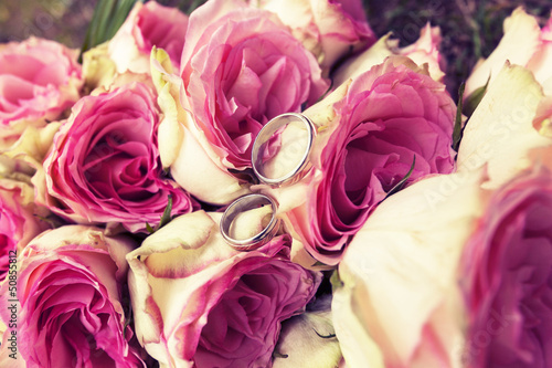 Wedding rings on a bouquet of red roses