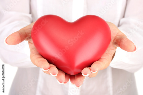 Red heart in woman s hands  on white background close-up
