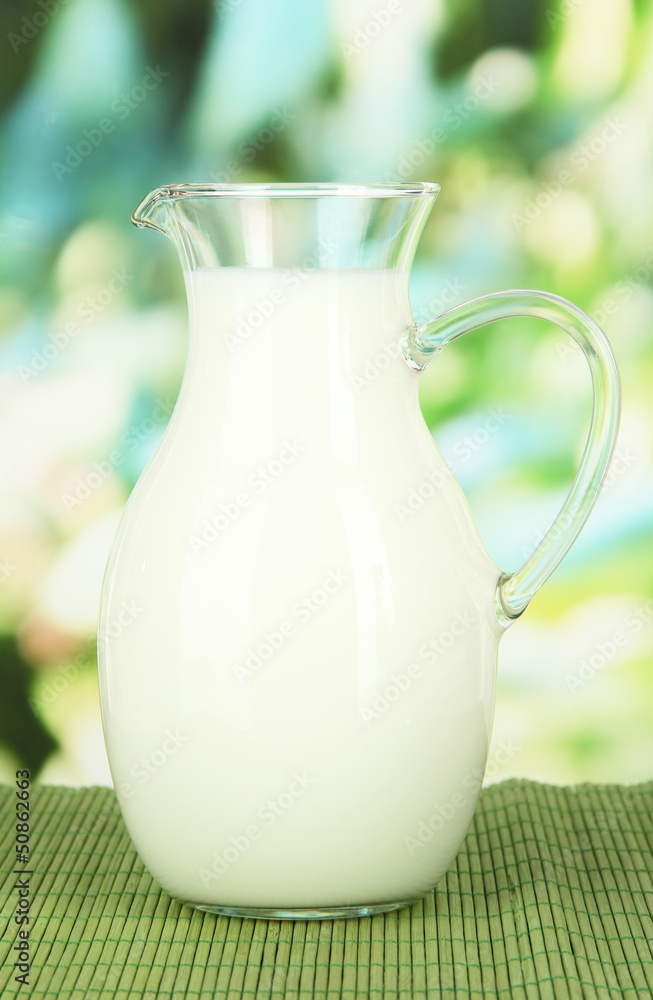 Pitcher of milk on table on bright background Pitcher of milk on table on bright background