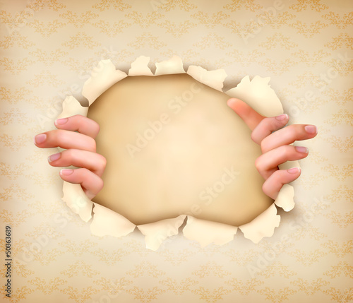 Vintage background with hands showing trough a hole of in old pa