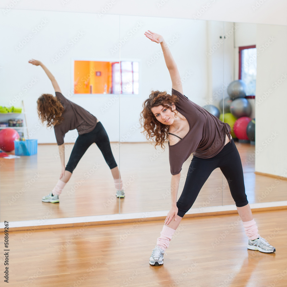 © pio3 - Young woman stretching her leg in the gym.
