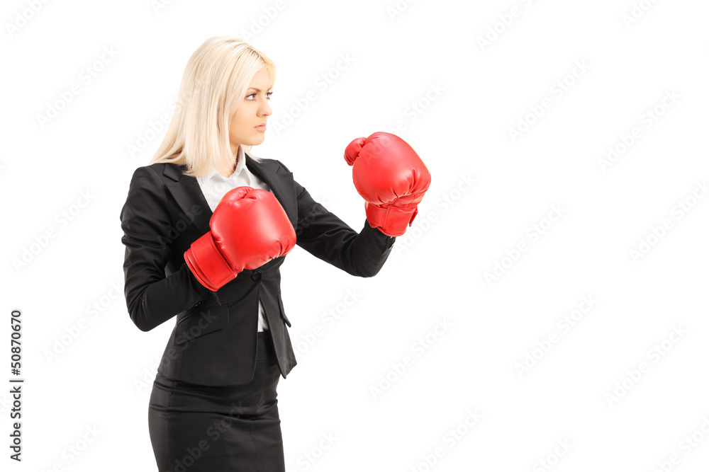 A young businesswoman with red boxing gloves ready to fight