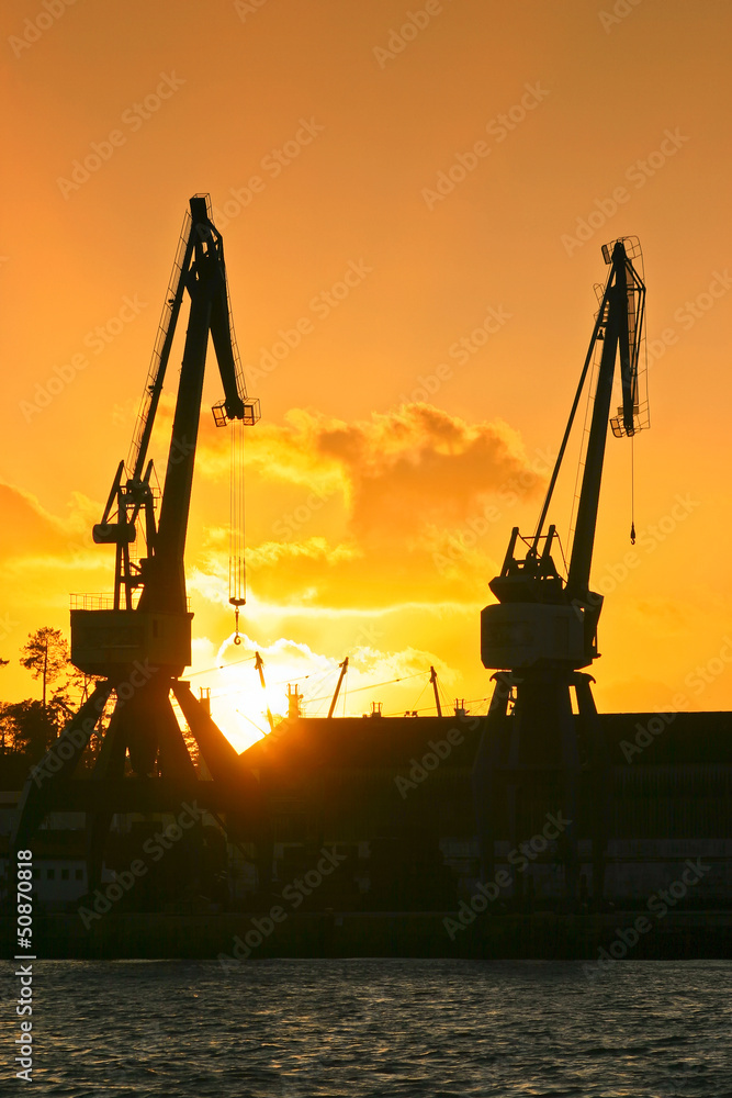 Harbor cranes at sunset on Vilagarcía de Arousa dock Harbor cranes at sunset on Vilagarcía de Arousa dock