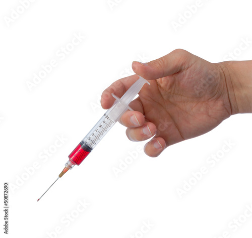 Hand holding syringe filled with red liquid.