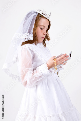Young girl in First Communion Attire with bible and rosary