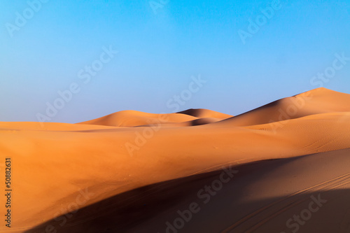 Fototapeta Naklejka Na Ścianę i Meble -  Arabian desert dune background on blue sky