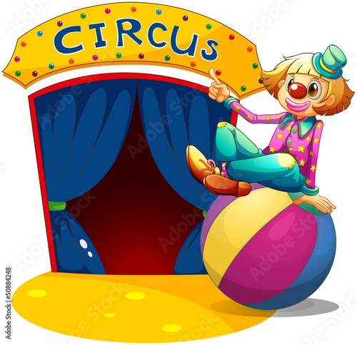 A clown sitting at the top of a ball pointing the circus house