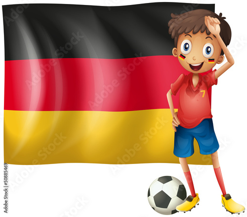 A boy with a soccer ball in front of the flag of Germany