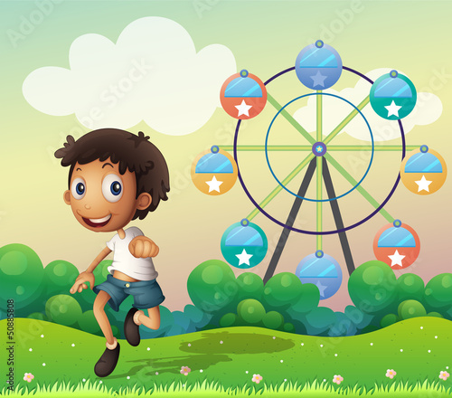 A boy in front of a ferris wheel