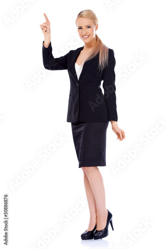 Smiling blond business woman pointing at copy space