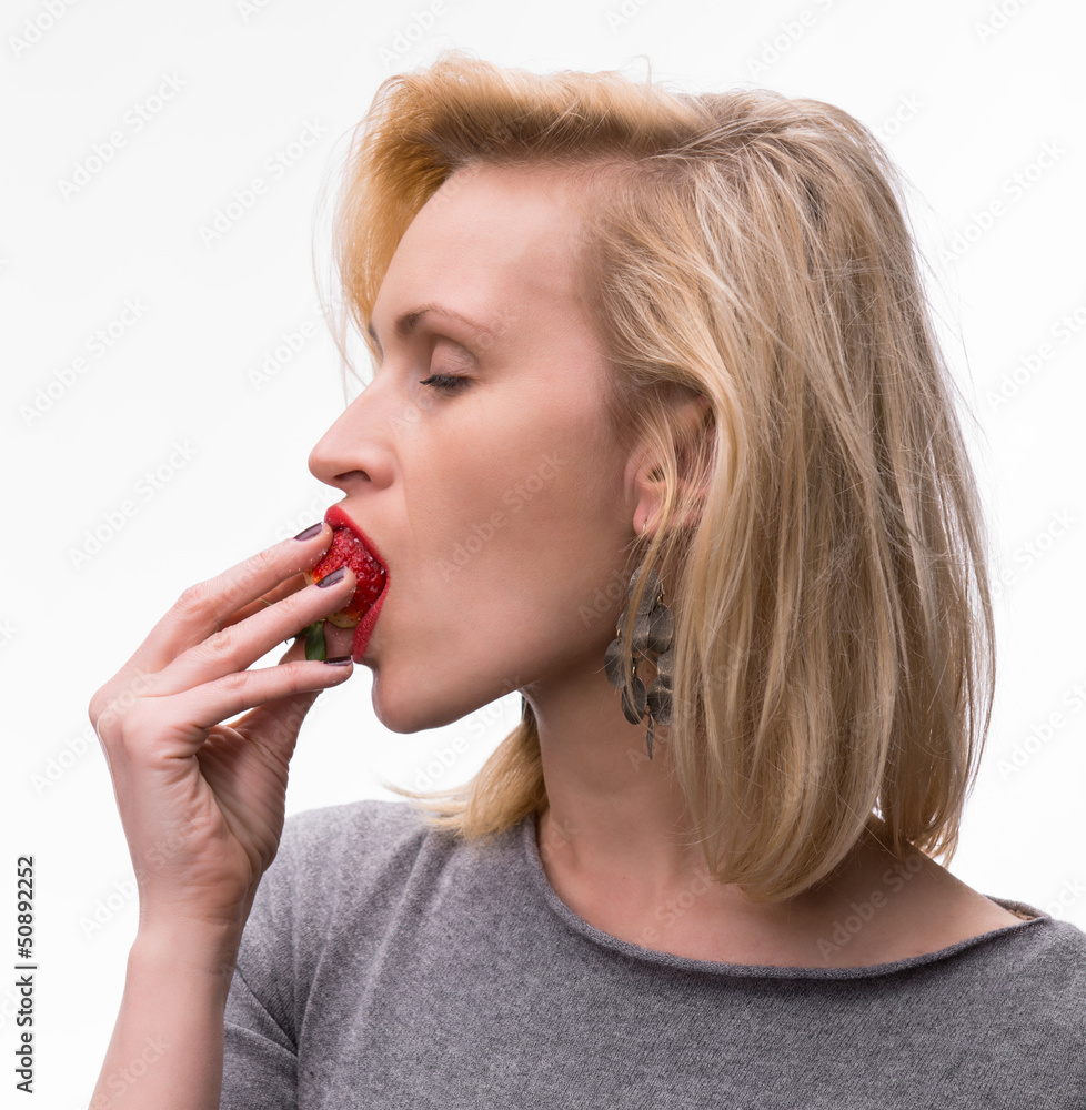 Portrait of a woman enjoying eating strawberries Portrait of a woman enjoying eating strawberries
