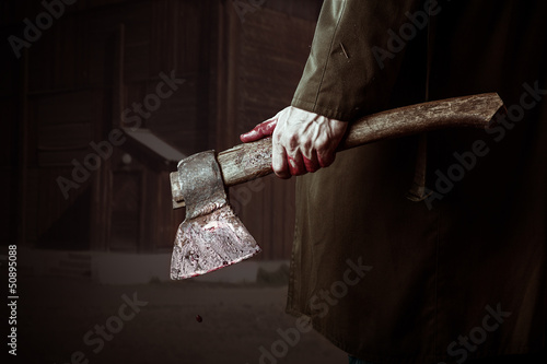 Axe with blood in male hand photo