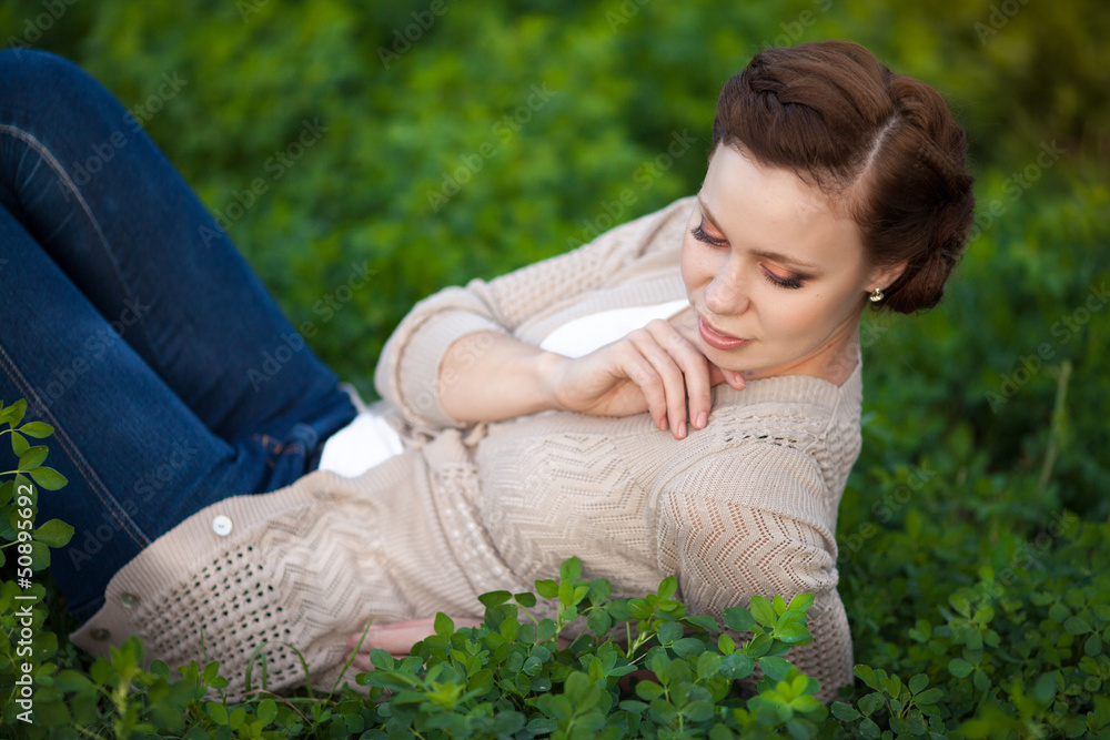 Happy woman resting on spring nature. Brunette girl at park Happy woman resting on spring nature. Brunette girl at park