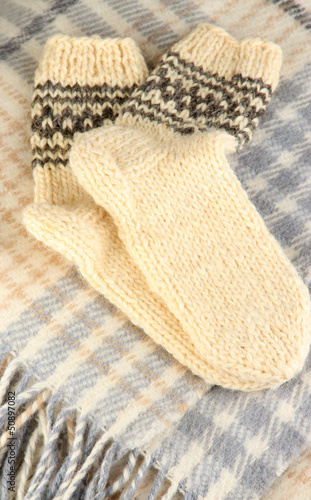 Warm knitted socks on plaid close-up