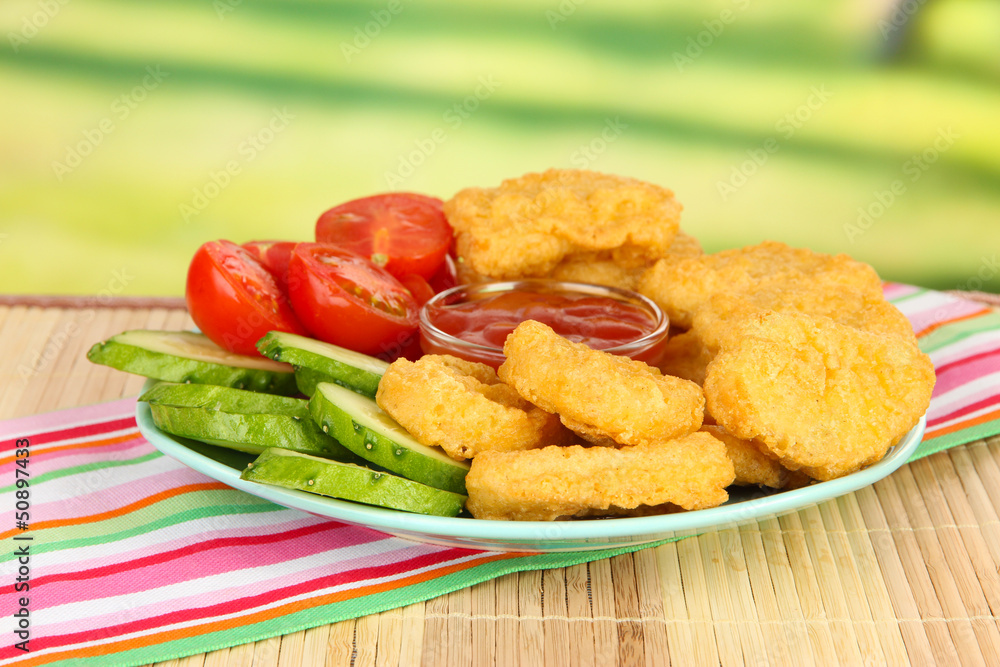 Fried chicken nuggets with vegetables and sauce on table in Fried chicken nuggets with vegetables and sauce on table in