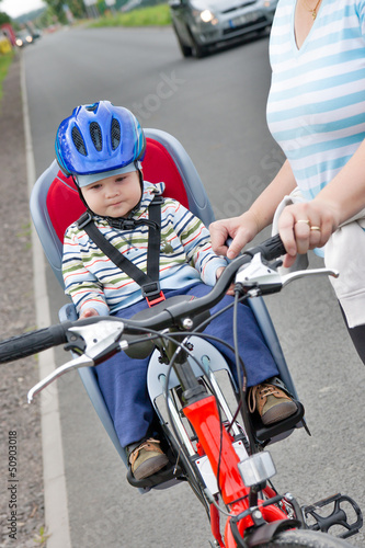 little boy with blue helmet on bicycle with mother