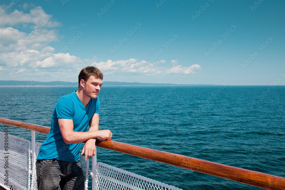 The young man on the deck against the sea